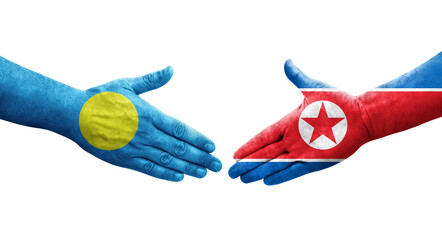 Handshake between North Korea and Palau flags painted on hands, isolated transparent image.