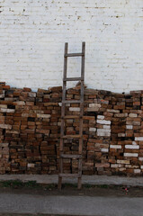 Wooden ladder against bricks