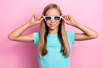 Naklejka premium Photo of cheerful sweet small kid wear turquoise t-shirt arms dark spectacles smiling isolated pink color background