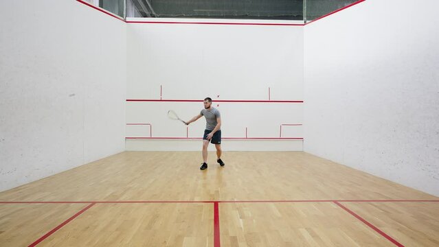 Athlete practices strokes with racket against side walls