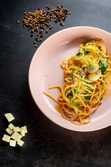 delicious appetizing classic spaghetti pasta with tomato sauce, parmesan in plate on black background