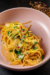 delicious appetizing classic spaghetti pasta with tomato sauce, parmesan in plate on black background