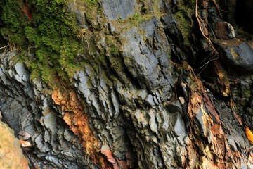 A large layered sedimentary river rock sits on the river Boro-Boro, Southeast Sulawesi, Indonesia.