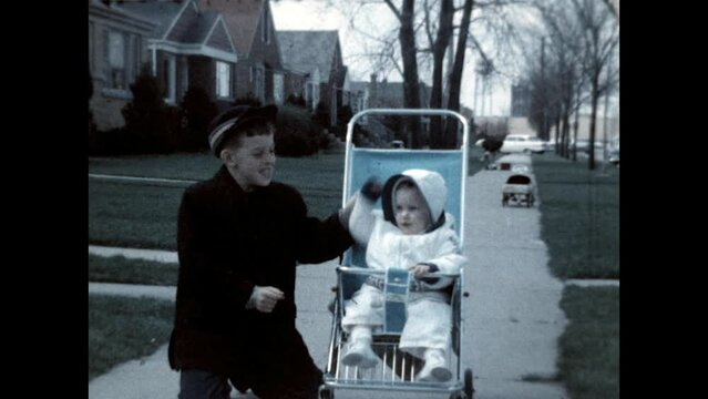 Sister in a Stroller 1961 - A boy entertains his baby sister as she sits in a stroller in 1961. 