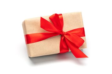 Close up shot of gift box wrapped in craft paper and decorated with red satin ribbon, isolated on...