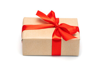 Close up shot of gift box wrapped in craft paper and decorated with red satin ribbon bow, isolated on white background
