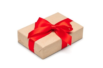 Close up shot of gift box wrapped in craft paper and decorated with red satin ribbon, isolated on white background