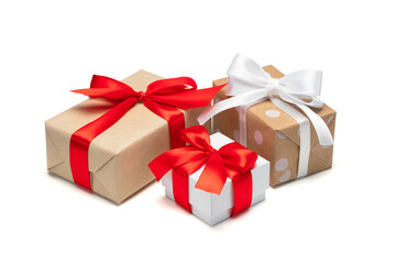 Close up set of three gift boxes wrapped in craft paper and decorated with satin ribbon bows, isolated on white background - 544999115