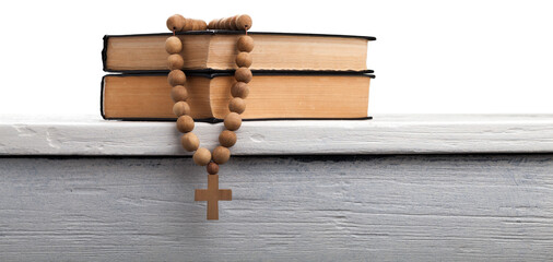 The book of Catholic and rosary beads on the wooden table