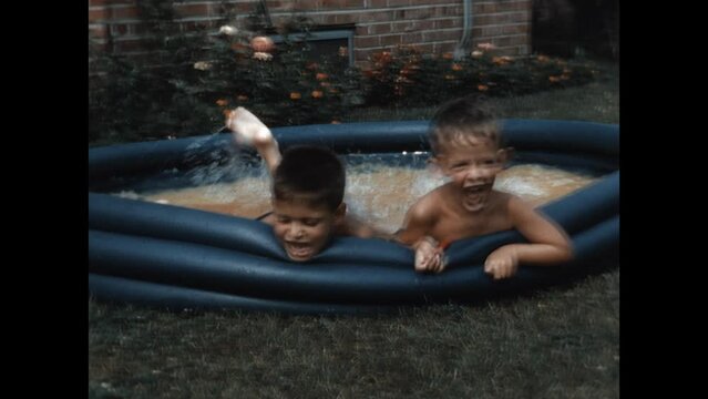 Playing in the Kiddie Pool 1954 - Two brothers splash in a kiddie pool in their suburban Chicago home in 1954. 