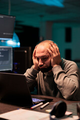Overworked programmer working on app developing after hours, feeling tired and stressed about it...