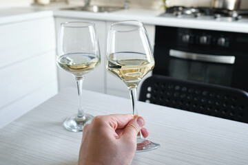 A glass of wine or champagne in the hands of a man. Tasting of alcoholic beverages. Celebrate and enjoy the moment. Glass of wine close-up
