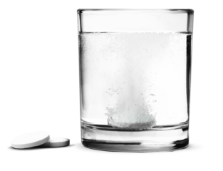 Glass with water and white medical pill