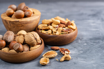 various nuts in a wooden bowl and a nutcracker. Close-up. selective focus.