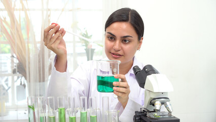 Biologist asian young woman wear lab-coats examining specialist test tube microscope chemist in...