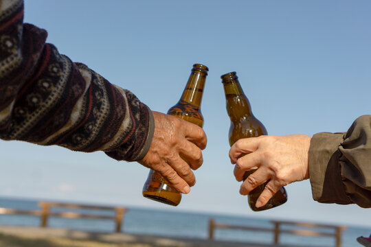 Middle aged or senior people drinking beer.  Two people toasting outdoors.  ビールを飲む中高年またはシニア仲間。屋外で乾杯する二人。