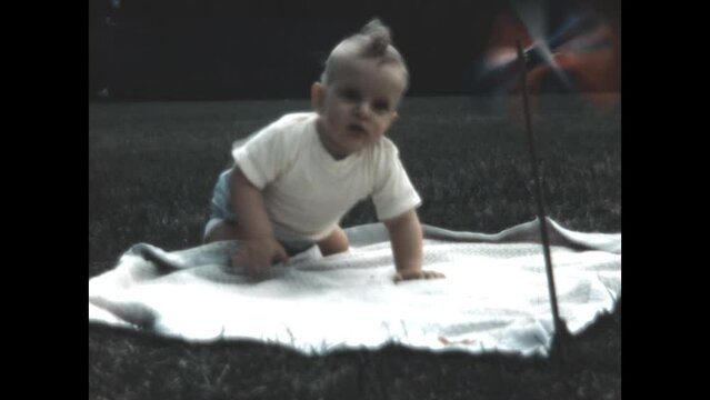 Baby Watches Pinwheel 1951 - A baby watches a pinwheel as it spins in the wind in 1951. 