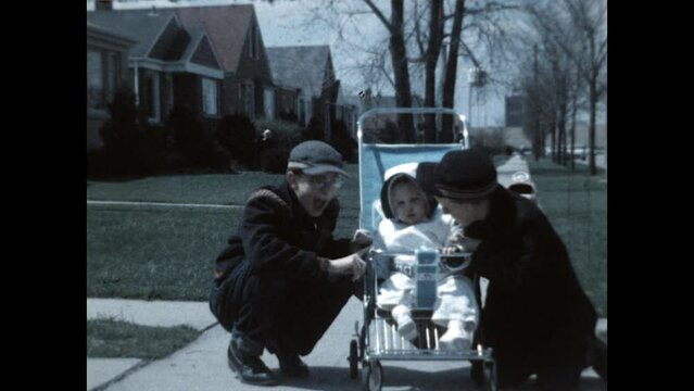 Baby Sister in a Stroller 1961 - Brothers gather around their baby sister in a stroller and mom pushes her down the sidewalk in 1961. 