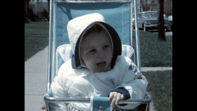 Baby in a Stroller 1961 - A baby girl in a winter coat sits in her stroller in 1961. 