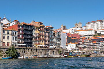 Fototapeta na wymiar Views of the famous Ribeira neighborhood, one of the most authentic and picturesque part of the town, an UNESCO World Heritage Site, as seen from the River Douro in Porto, Portugal