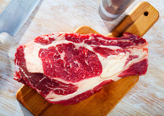 Ingredients for cooking. Fresh raw beef entrecote on wooden cutting board. High quality photo