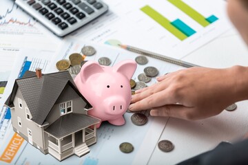 Concept of tax, businessman with toy house on the desk