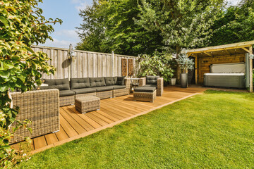 Neat paved patio with sitting area and small garden near wooden fence - obrazy, fototapety, plakaty