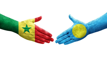 Handshake between Palau and Senegal flags painted on hands, isolated transparent image.