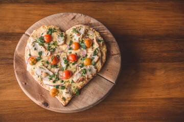 pizza con forma de corazón, tomates 