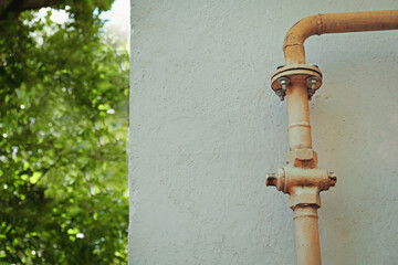 Yellow metal pipe near wall outdoors, space for text