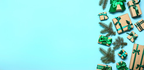 Many Christmas gifts and fir branches on light blue background with space for text
