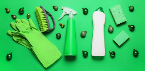 Cleaning supplies and decor on green background. Christmas cleanup