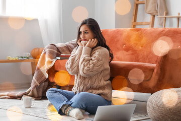 Beautiful young woman in warm sweater resting at home