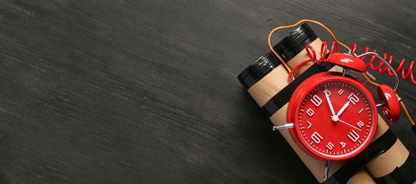 Bomb with alarm clock on wooden background with space for text