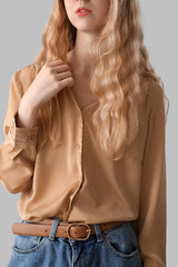 Young woman with blonde hair on light background