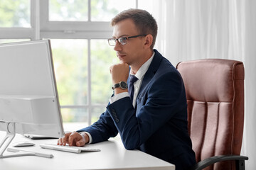 Obraz premium Young bank manager working with computer at table in office