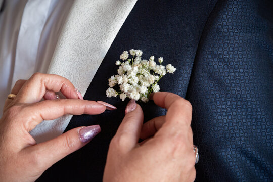 foto che ritrae il momento del fiore all'occhiello nell'abito dello sposo prima della cerimonia