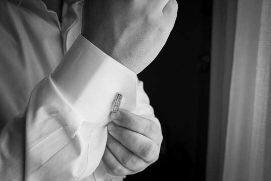 dettagli durante una cerimonia che ritrae lo sposo che si aggiusta il polsino della camicia e mostra il  dettaglio del polso e gemelli gioielli , orologio da polso del suo matrimonio   