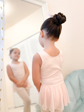 Little ballerina looking at herself in the mirror
