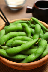 Green edamame beans in pods served on wooden table, closeup
