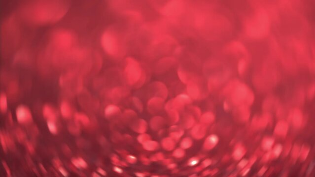 Brilliant background for Christmas and new year holiday. Red moving sniny sequins rhinestones and particles create a beautiful magic bokeh