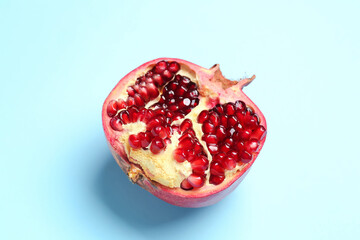 Half of fresh pomegranate on color background