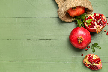 Sack bag with ripe pomegranates on color wooden background