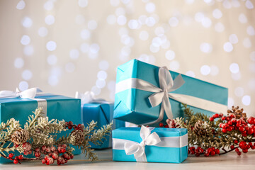 Christmas gifts and decor on table against blurred lights, closeup