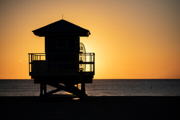 Life Guard tower is silhouetted against a colorful sunrise on Hollywood Beach, Florida