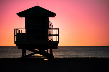 Life Guard tower is silhouetted against a colorful sunrise on Hollywood Beach, Florida