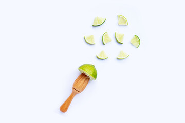 Fresh lime with wooden juicer on white background. Copy space