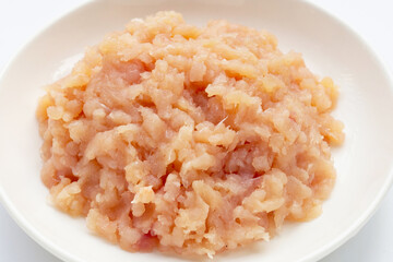 Minced meat of chicken fillet in white plate on white background.