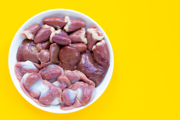 Mixed chicken entrails in white plate on yellow background.