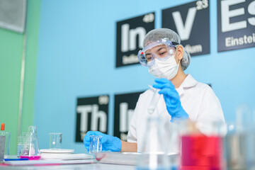 Modern medical research laboratories Beautiful female scientist wearing protective goggles mixes chemicals in test tubes in laboratory biochemical samples, an advanced science laboratory for medicine